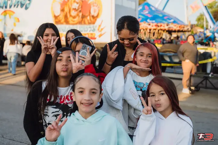 Grupo de jóvenes posando juntos en el área de atracciones de HispanoFest 202