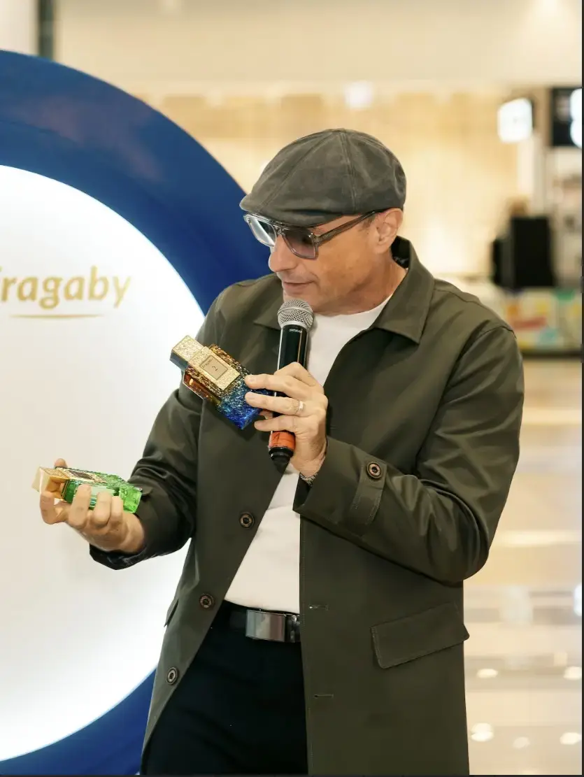 Modelo masculino con gorra y chaqueta negra posando con una fragancia de Fragaby Perfume, transmitiendo un estilo sofisticado
