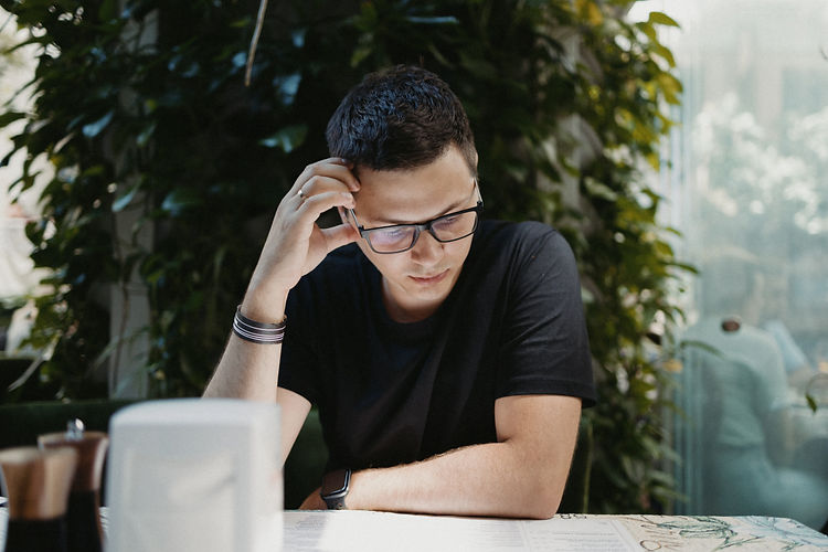 Man in a green cafe watching the menu_edited.jpg