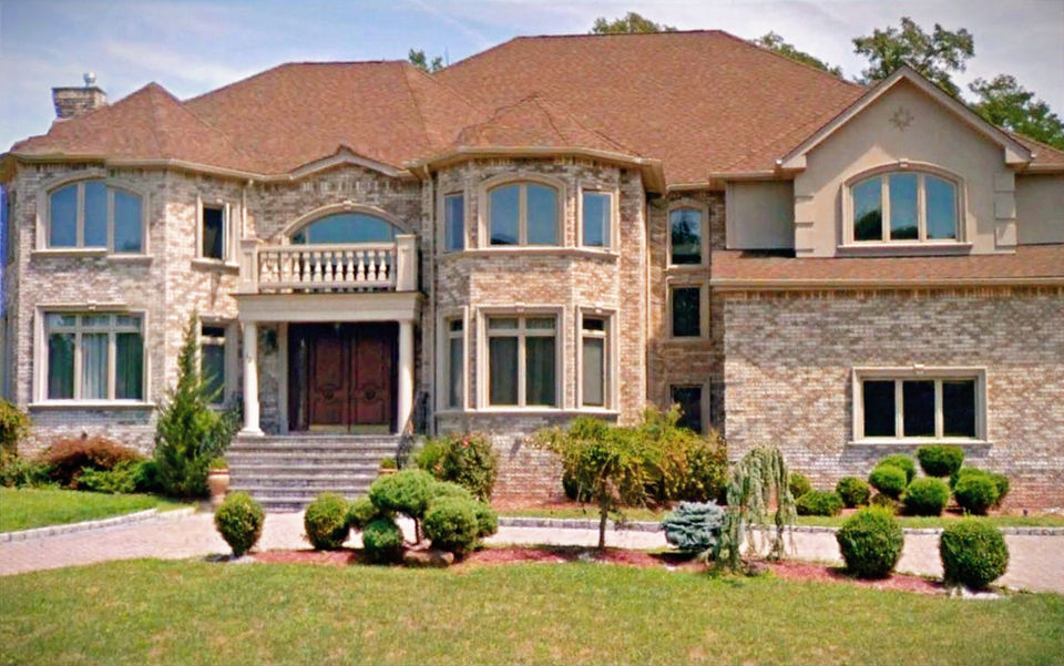 Single-family mansion with stone and multiple windows.