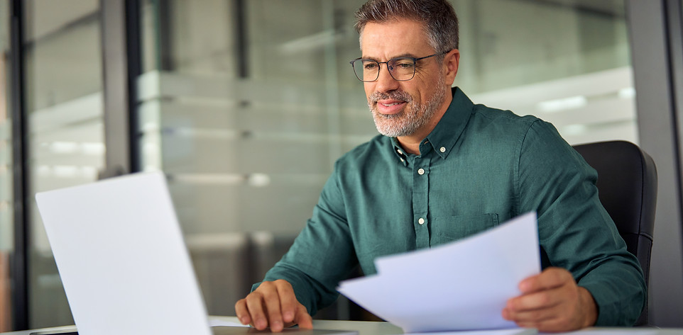 Strata manager reviewing Only Strata snow removal contracts on laptop — choosing seasonal vs per-service options