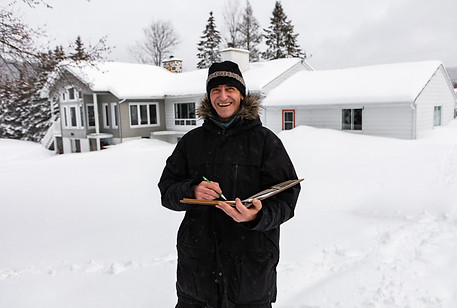 home Inspector during an inspection, middle aged man smiling and holding a notebook, he we