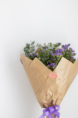 Ramo de flores lilas envuelto en papel kraft