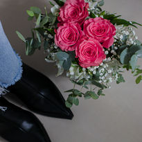 Botas negras y ramo de rosas: detalle elegante