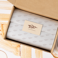 Caja abierta mostrando papel de regalo con su logo