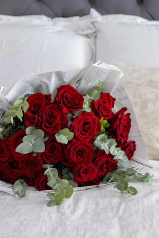 Ramo de rosas rojas sobre cama