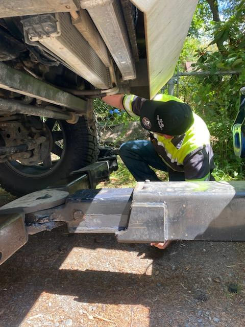 Frost Towing driver inspecting vehicle