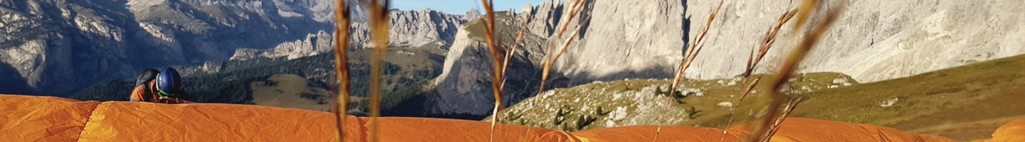 Ein orangener Gleitschirm im Gras
