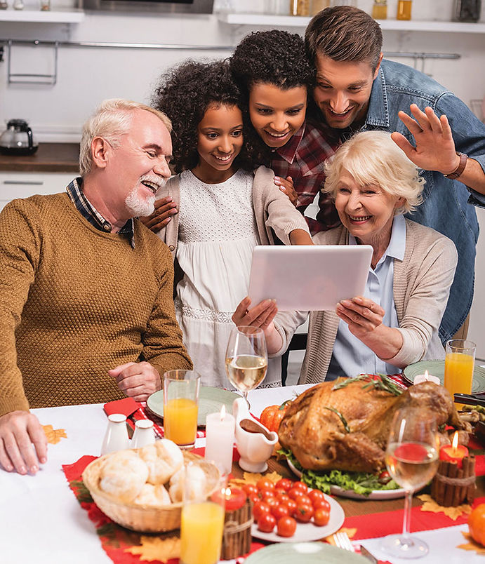 blended family looking at iPad at Thanksgiving dinner table