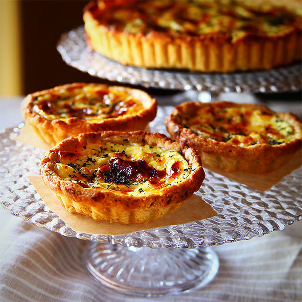 several freshly baked leek and goat cheese tarts on display for eating