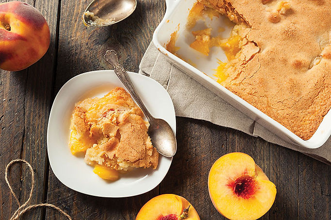 pan of peach cobbler and serving on a plate