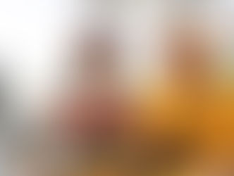 women in sweaters toast with glasses of wine as they sit outdoors at a table filled with food