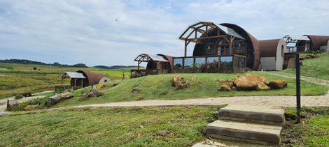 Fachada de cabana super luxo em formato de pipa de vinho deitada estilo Hobbit na Barragem do Divisa. Projeto em madeira e pedra por Rafael Zanatta Arq.
