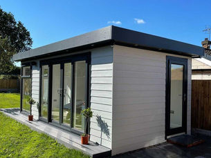 Light grey composite clad garden room with anthracite UPVC windows and doors by Cosy Garden Rooms.