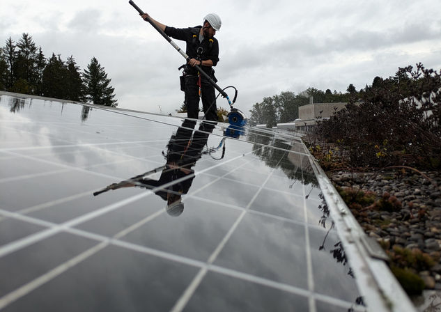 Mann reinigt Solarmodule