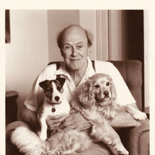Black and white photo of Roald Dahl with his two dogs
