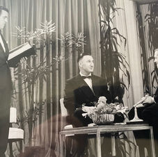 A black and white photograph from a TV set featuring Sir Richard Attenborough