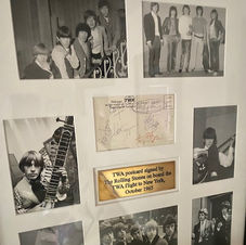 A framed collage of images of the band The Rolling Stones as a TWA card signed by the band