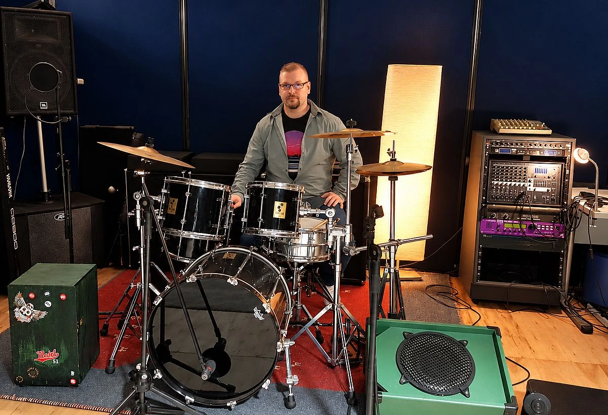 Musiker am Schlagzeug im Proberaum mit Aufnahme- und Tontechnik