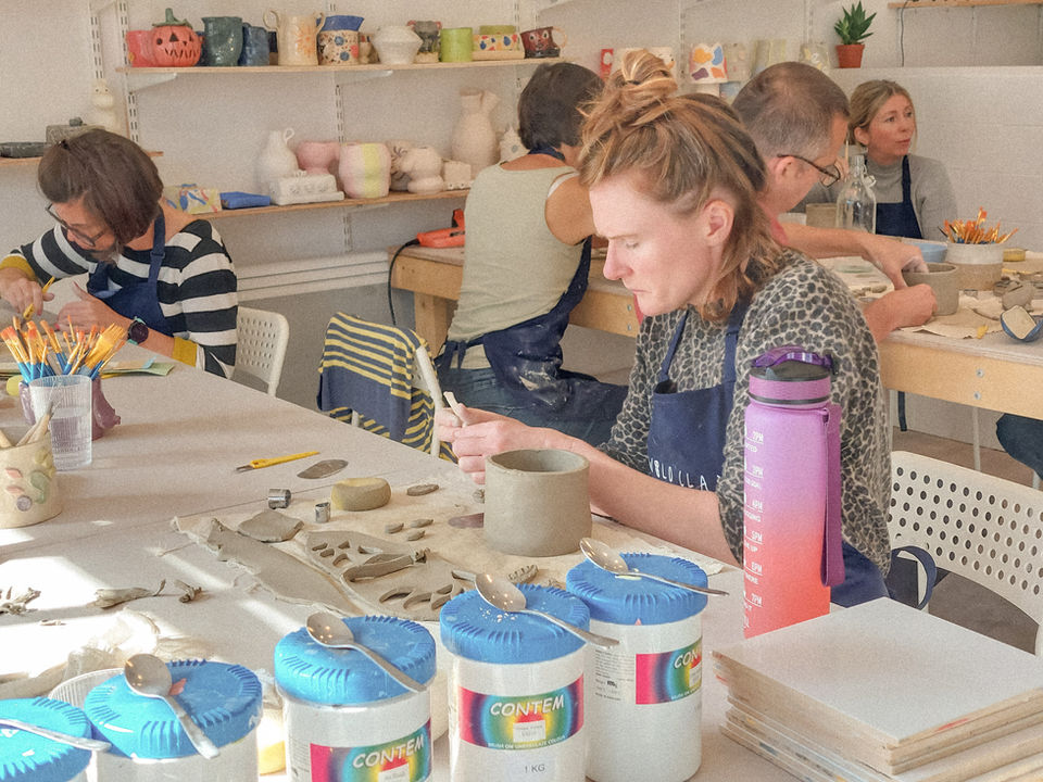 A pottery student making a ceramic plant pot.
