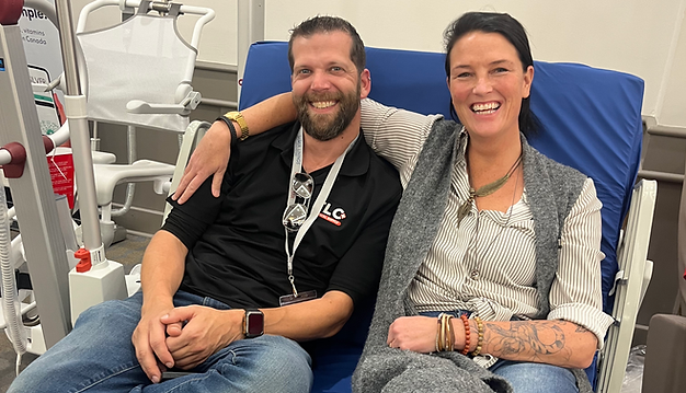 Staff from TLC and BuildAble owner sitting together on a medical supply bed smiling