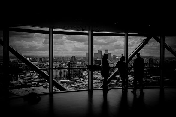 People discussing, near a window in a office building