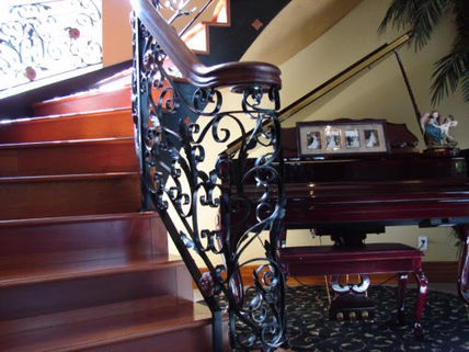 Ornate staircase with intricate wrought iron railing.