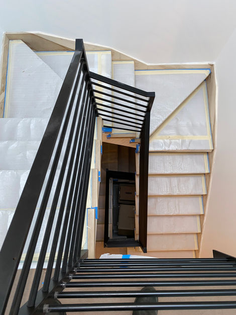 a staircase with a black railing and white steps