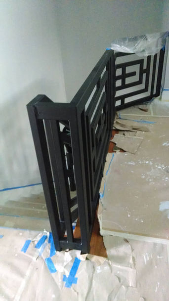Black geometric metal railing on stairs.
