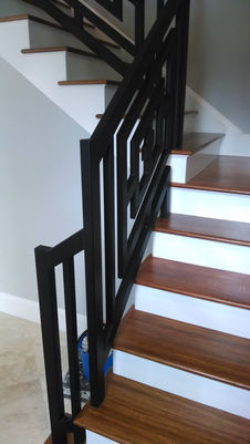 Wooden staircase with modern black railing design.