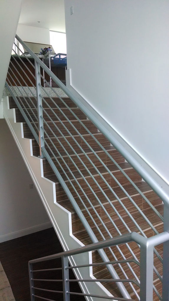 Metal railing on a wooden staircase.