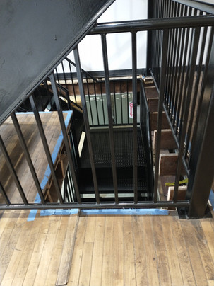 Staircase with metal railings and wooden steps.