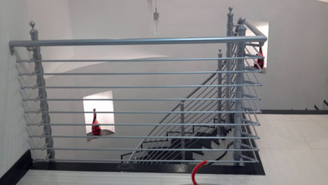 Metal railing with staircase in modern interior space.
