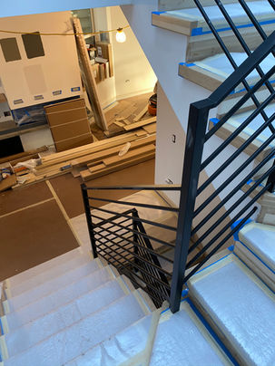 a staircase in a house under construction with a black railing