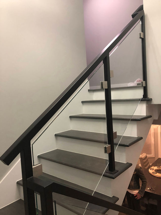 Modern staircase with glass railing and wooden steps.