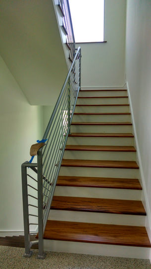 Wooden staircase with metal railing in a modern interior.