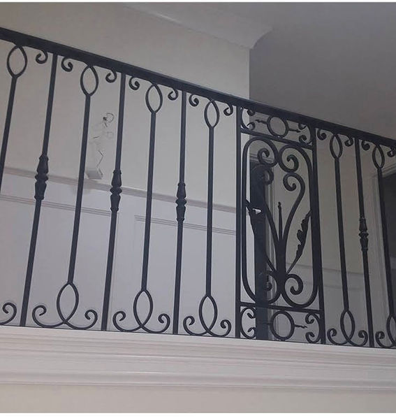 Ornate black wrought iron railing indoors.