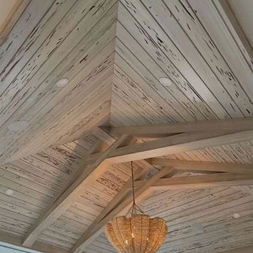 Vaulted ceiling with distressed wood planks and chandelier