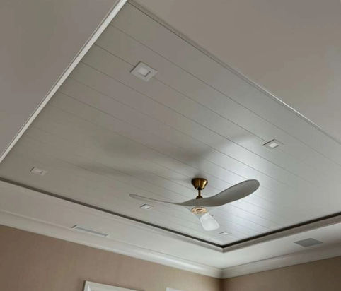 White tray ceiling with a ceiling fan