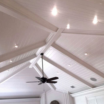 White vaulted ceiling with exposed beams and fan