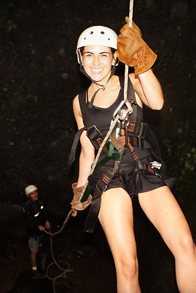 Amber Silva smiling as she rappels down a waterfall.