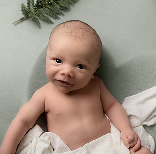 smiling baby boy close up green background portrait