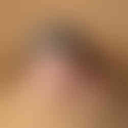 Hands under chin newborn photography pose with flat cap