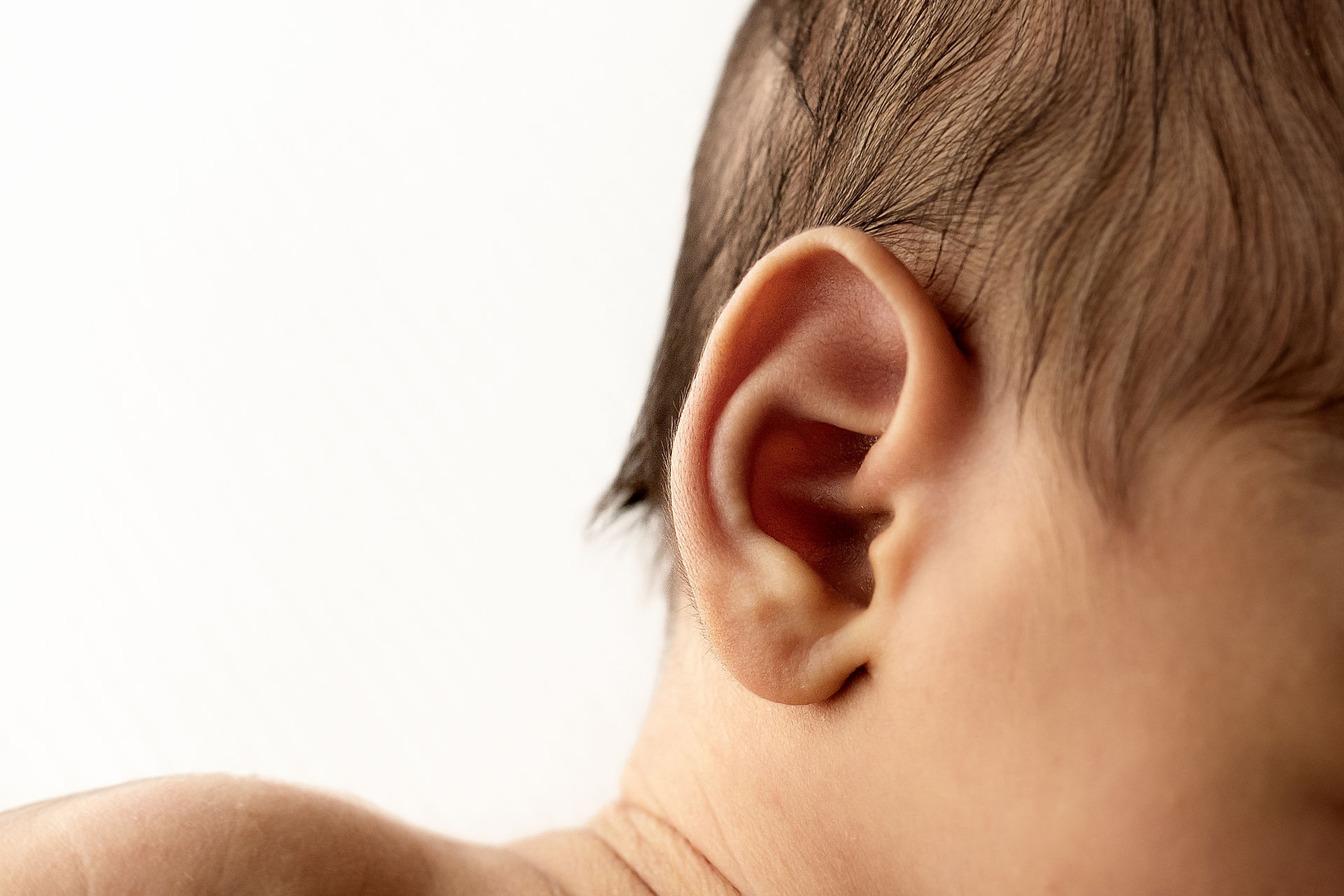 close up photography of newborn baby ear fuzz