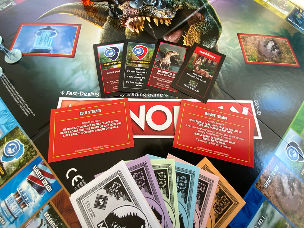 The Jurassic Park Monopoly Board, a selection of cards and money