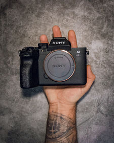 Cinematic product photography featuring a Sony A7IV camera, handmade dice, leather wallet and camera filter with detailed lighting and composition