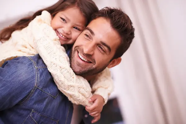A dad giving his daughter a piggy back ride.webp