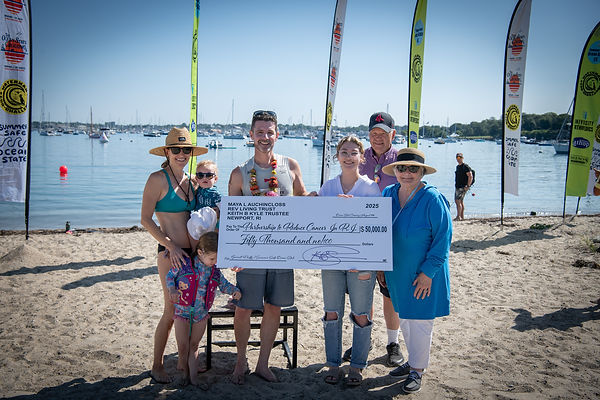 Group of people standing on the beach while holding a giant check in the amount of $50,000