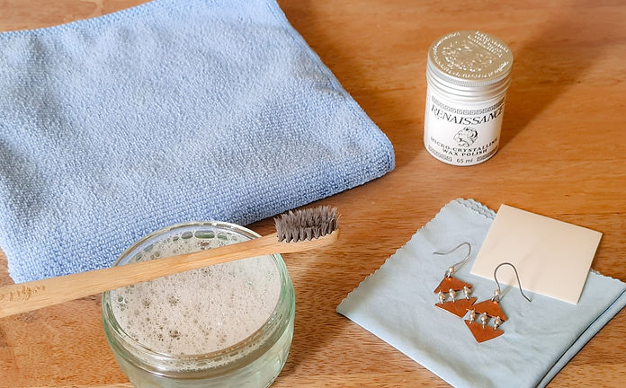 Microfiber cloth, soapy water, toothbrush, jewellery cleaning cloth, and Renaissance wax for cleaning jewelry.