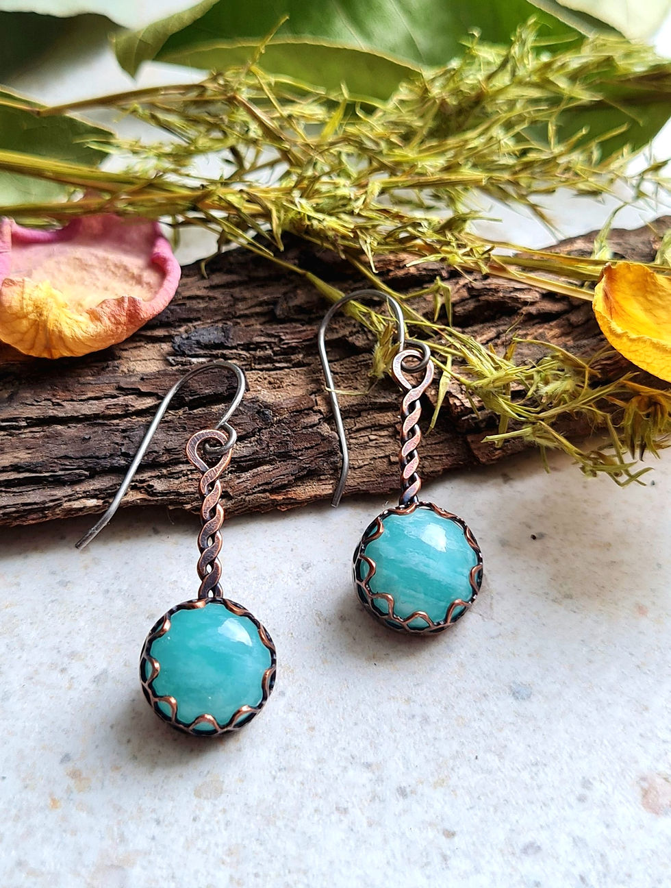 Budding Amazonite Earrings resting on moss and wood, handcrafted in copper with softly scalloped edges and twisted wire stems